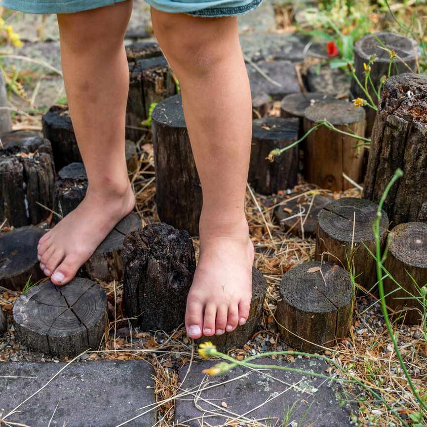 Close up van de blote voeten van een kind op een paadje