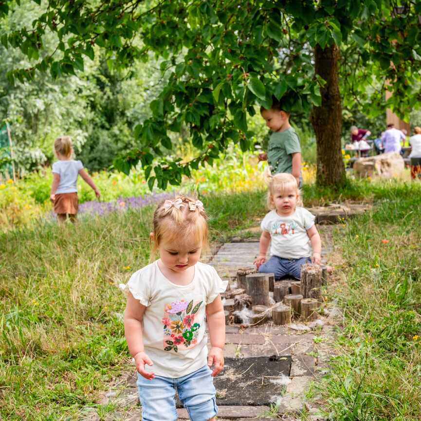 Vier kleine kinderen in de tuin