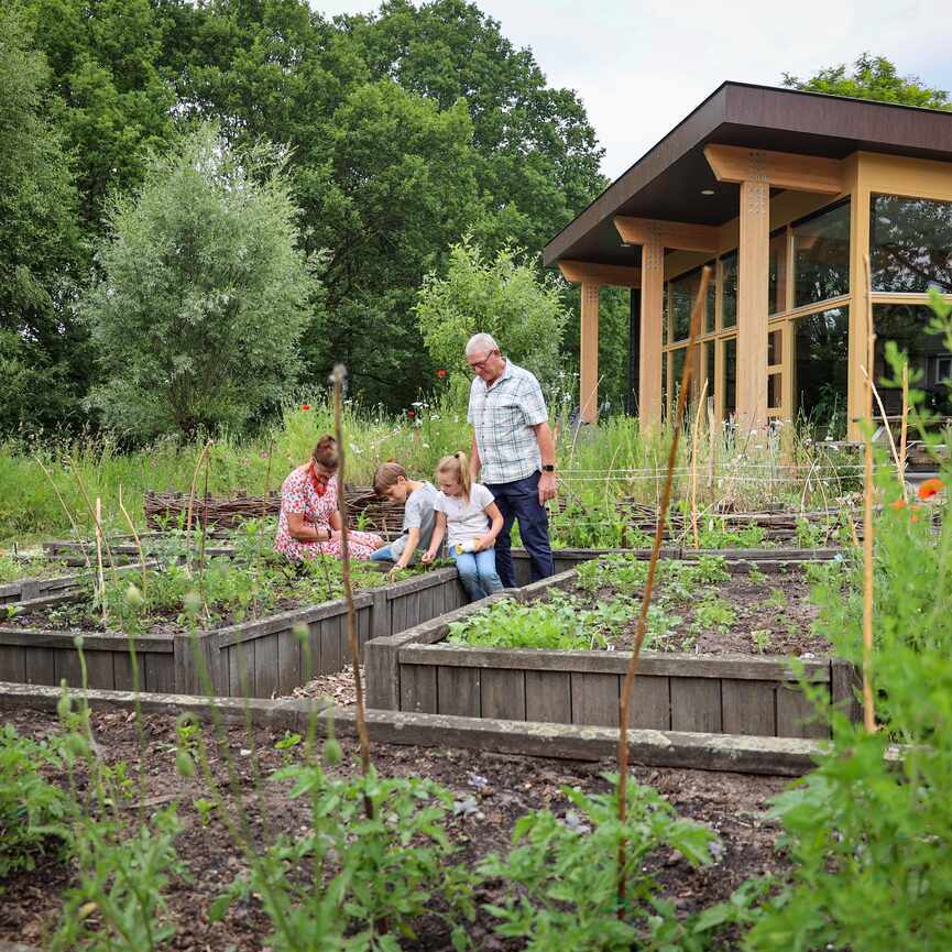 Man vrouw en kinderen in de moestuin