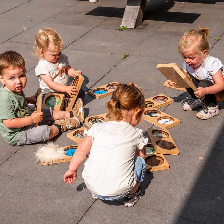 Vier kinderen spelen op de grond